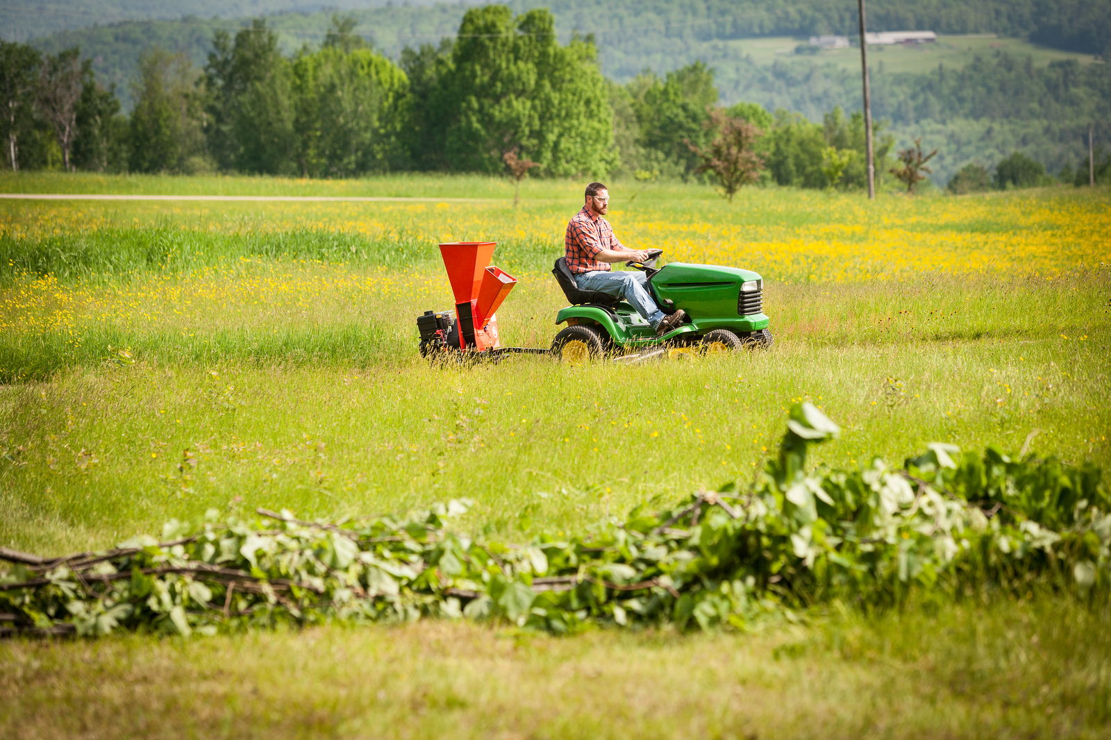 Flishuggeren fra DR Power bakhengt på mini-traktor gjennom blomsterengen