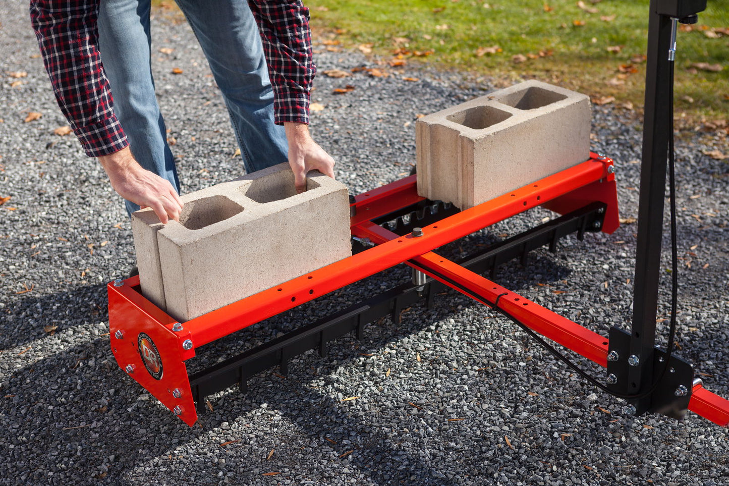 Bakmontert Veihøvel fra DR Power med betongklosser oppå for å bedre ferdig resultat