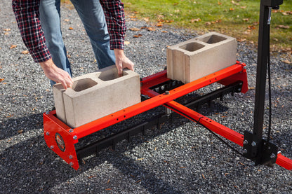 Bakmontert Veihøvel fra DR Power med betongklosser oppå for å bedre ferdig resultat