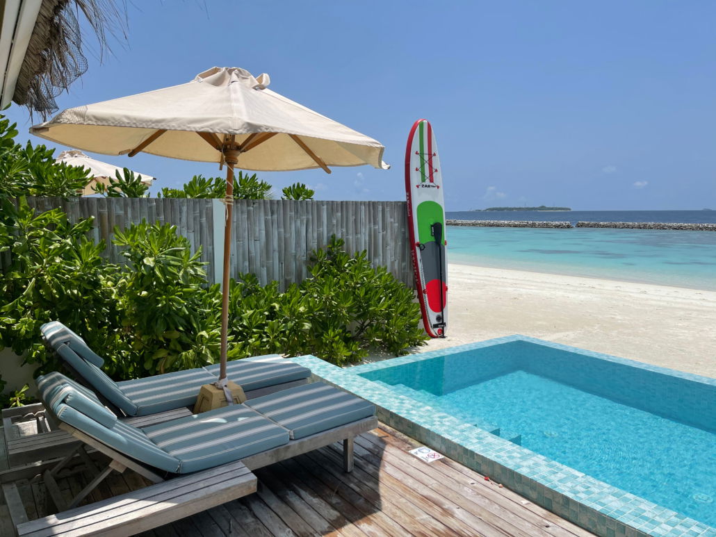 SUP brett fra Zar mini stående ved basseng, turkis sjø i bakgrunnen